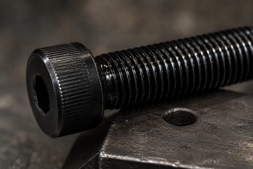 Close-up of black oxide coated screw threads with oil sealed finish