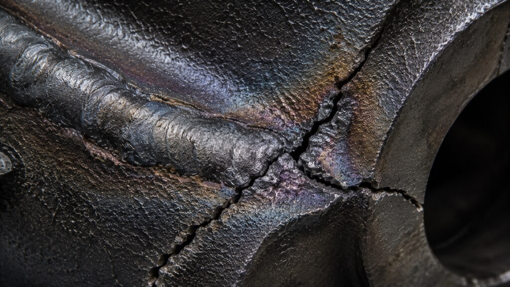Cracked cast iron weld failure beside heat affected zone caused by thermal stress and rapid cooling